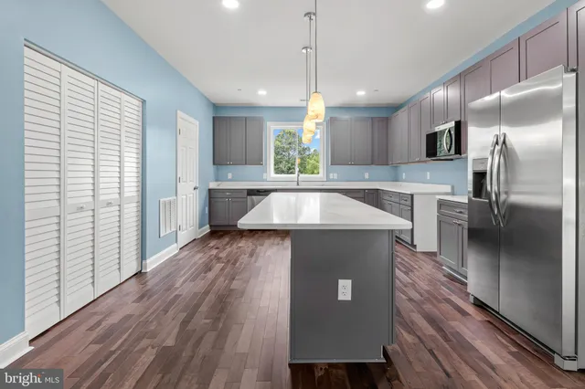 a large kitchen with kitchen island a large counter space a sink appliances and cabinets