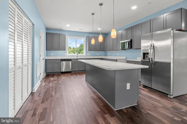 a kitchen with stainless steel appliances granite countertop a sink a stove and refrigerator