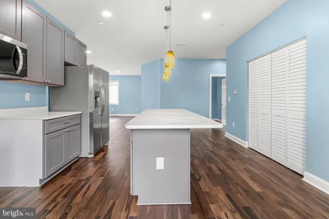 a kitchen with stainless steel appliances a stove cabinets and wooden floor