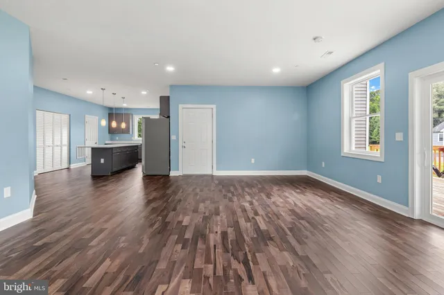 a view of a big room with wooden floor and windows