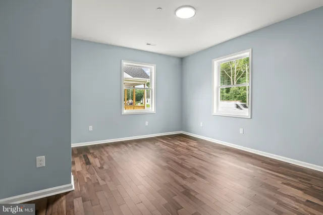 an empty room with a window and wooden floor