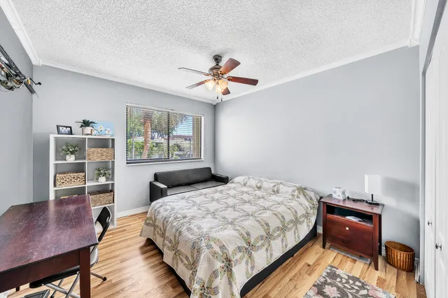 a bedroom with a bed and a desk with stool