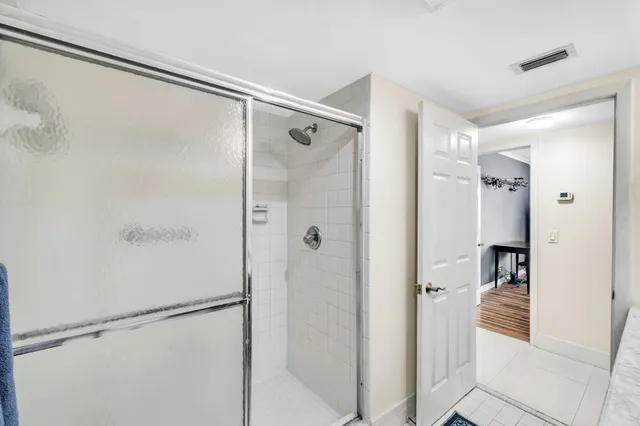 a bathroom with a shower and a glass door