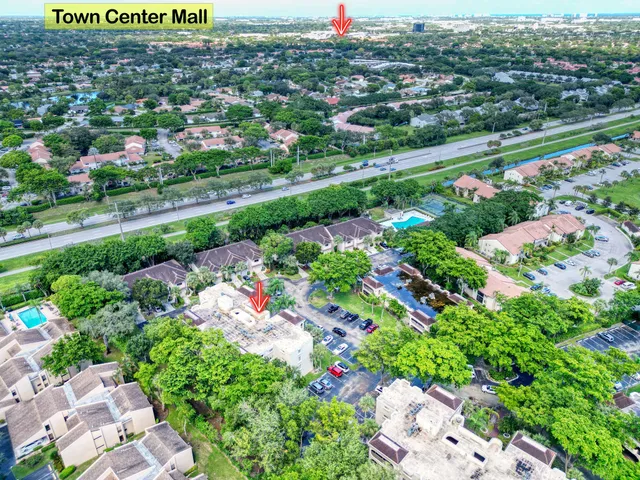 an aerial view of residential houses with outdoor space and trees