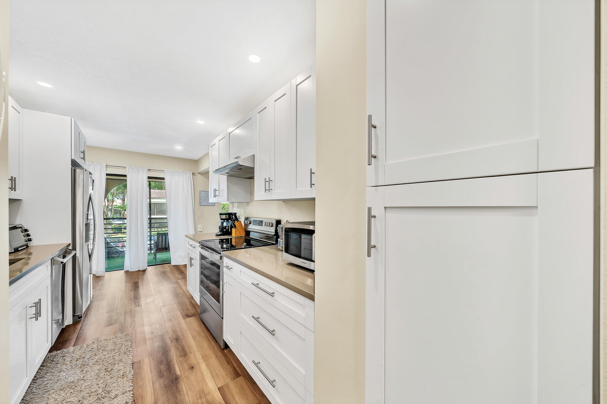 6342 Longboat Lane West, Unit 201 Boca Raton, FL 33433 - Photo 4 of 40 a kitchen with stainless steel appliances a refrigerator sink and cabinets