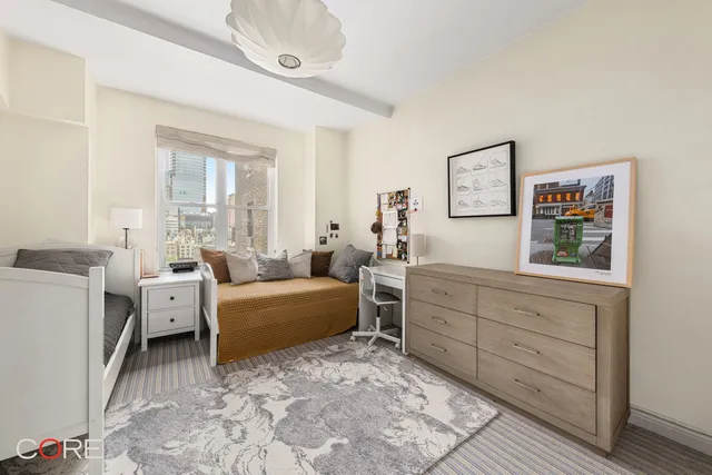 a living room with furniture and a baby crib