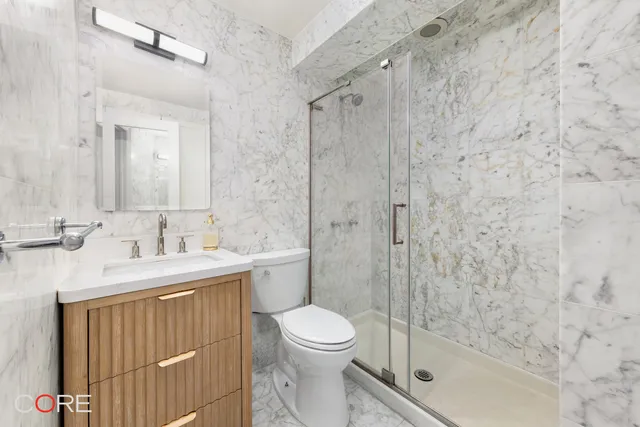 a bathroom with a sink a toilet and shower