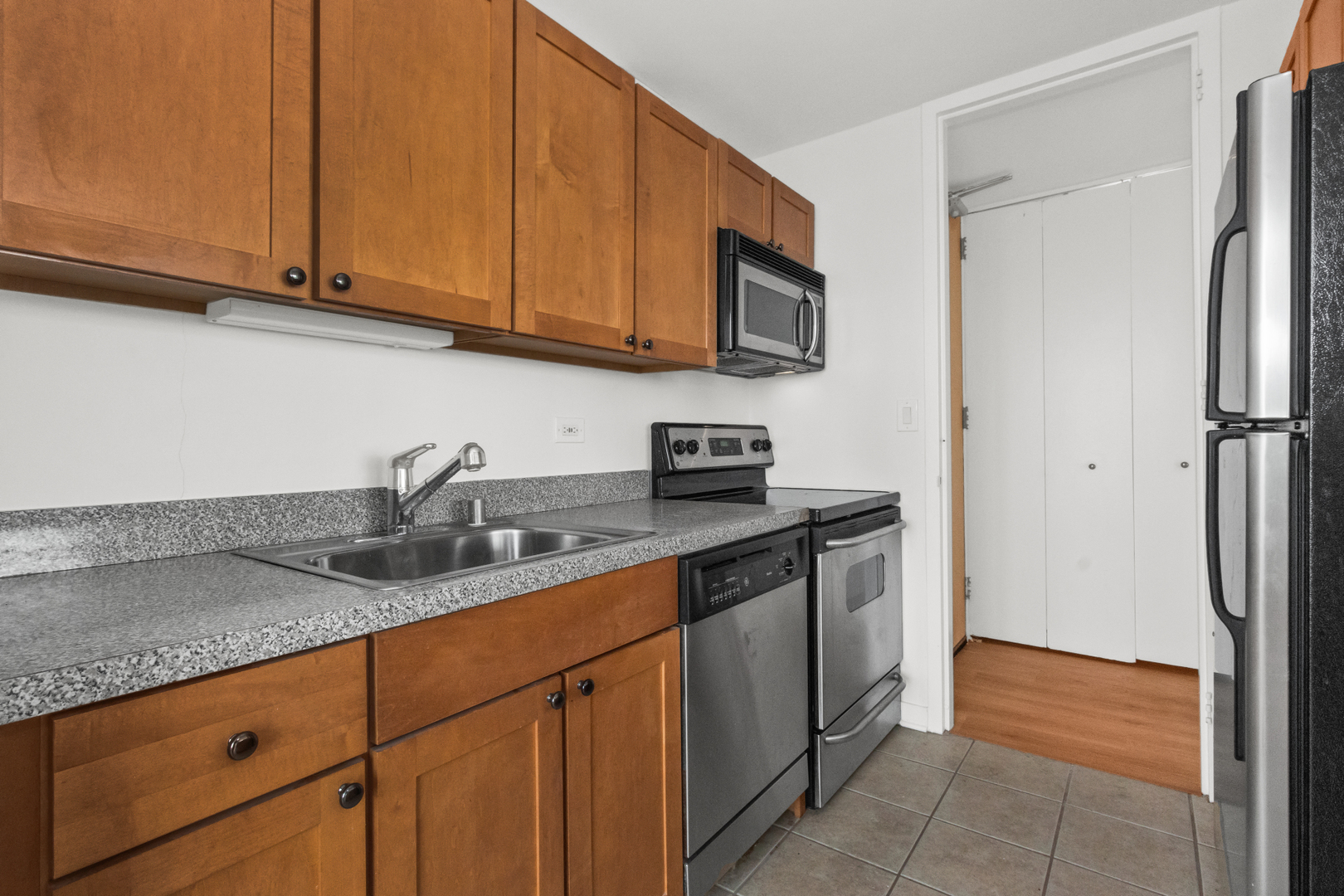 655 West Irving Park Road, Unit 4417 Chicago, IL 60613 - Photo 10 of 24 a kitchen with stainless steel appliances granite countertop a refrigerator and a sink
