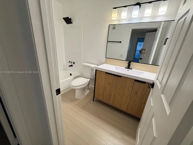 a bathroom with a sink and mirror with toilet