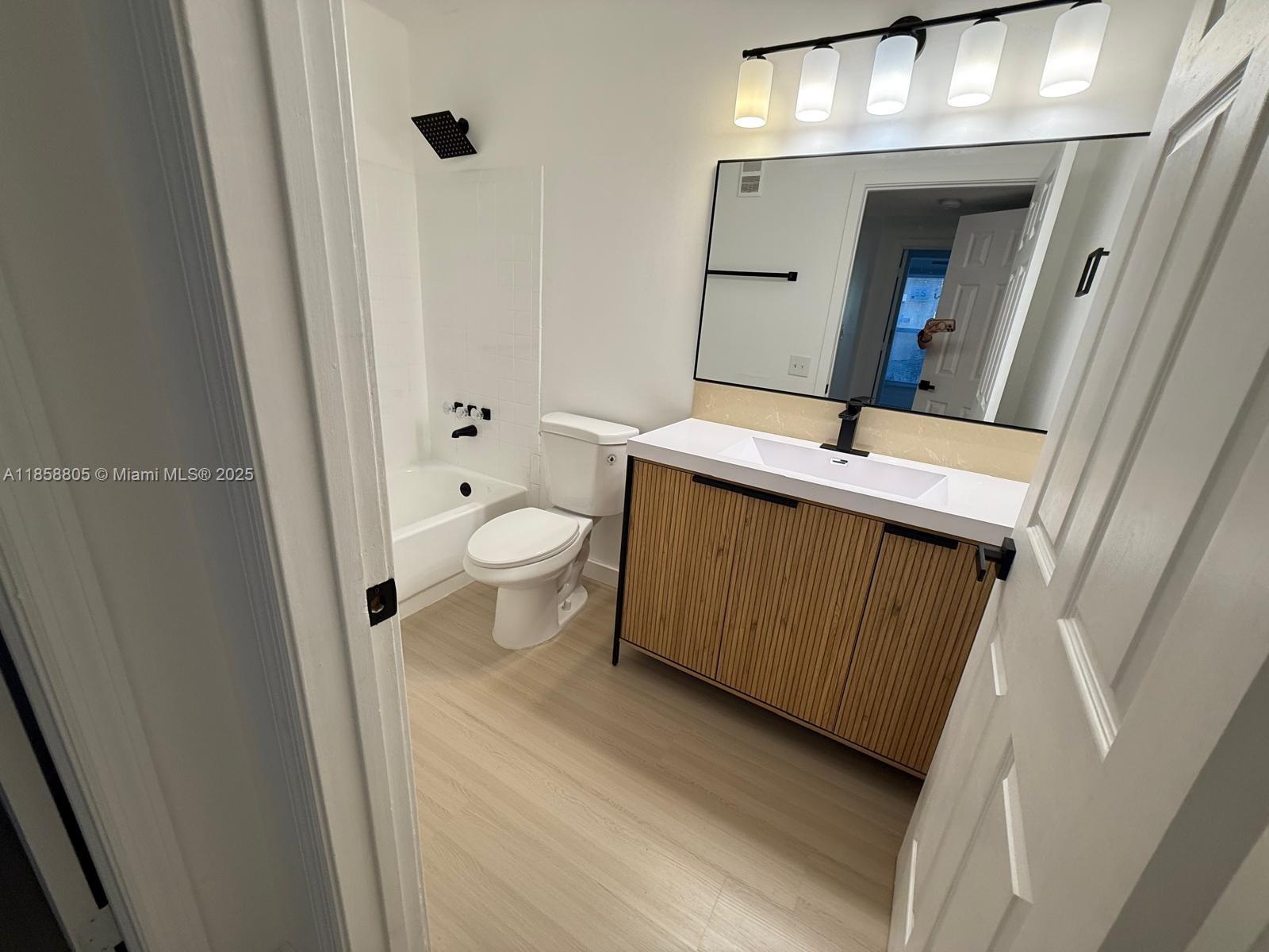 2319 North Congress Avenue, Unit 15 Boynton Beach, FL 33426 - Photo 15 of 20 a bathroom with a sink and mirror with toilet