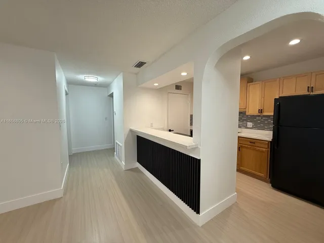 a kitchen with stainless steel appliances kitchen island granite countertop a refrigerator a sink and a stove