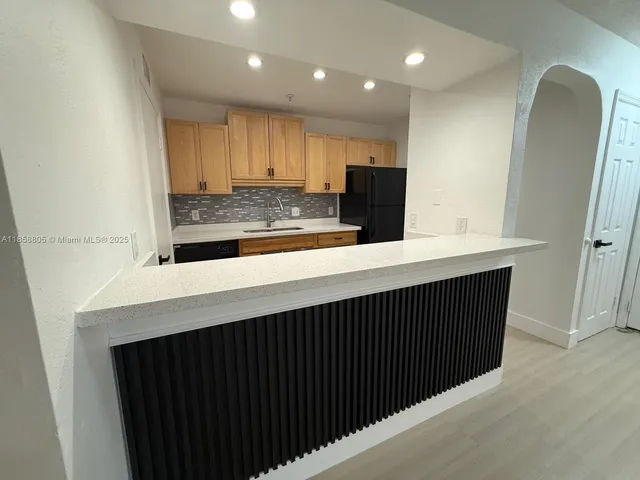a kitchen with a sink stainless steel appliances a counter space and cabinets