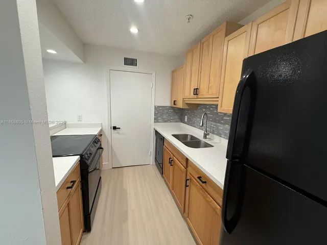 a kitchen with granite countertop a sink stove and refrigerator