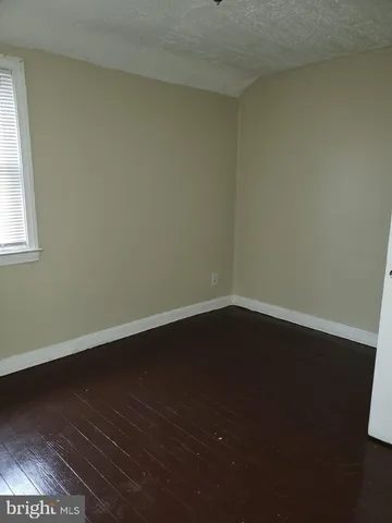 a view of a room with wooden floor and a window