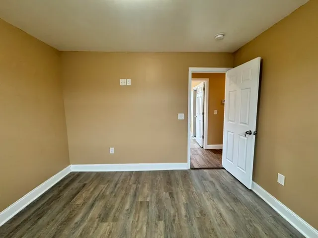 an empty room with closet and windows