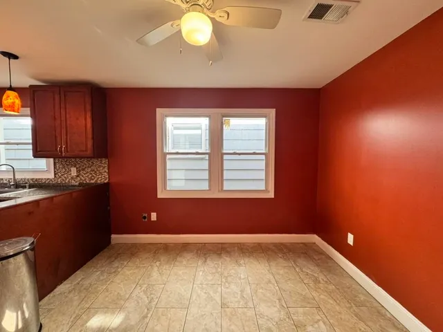 a view of a living room with kitchen and a window