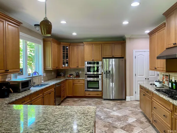 a kitchen with stainless steel appliances granite countertop a stove refrigerator sink and dishwasher