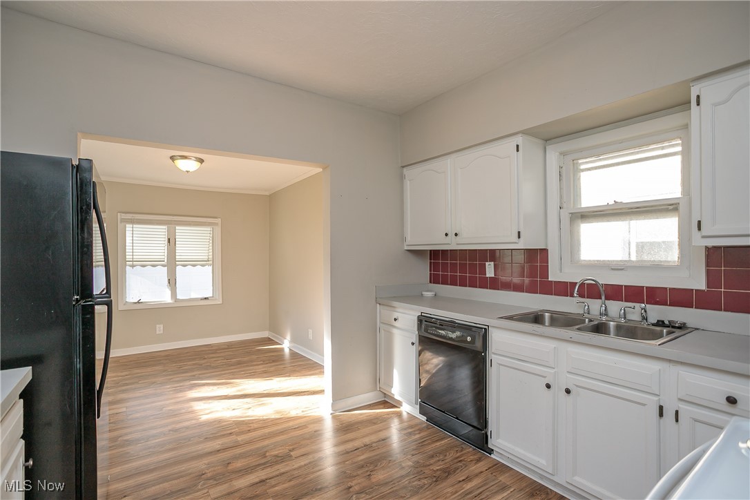 3666 Ludgate Road Cleveland, OH 44120 - Photo 10 of 22 Kitchen with backsplash, sink, black appliances, hardwood / wood-style flooring, and white cabinetry