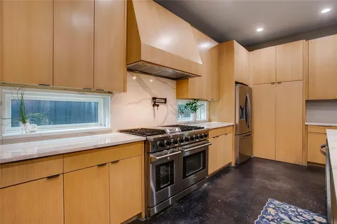 a kitchen with stainless steel appliances granite countertop a stove a refrigerator and a microwave