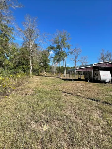 a yellow house with trees in the background