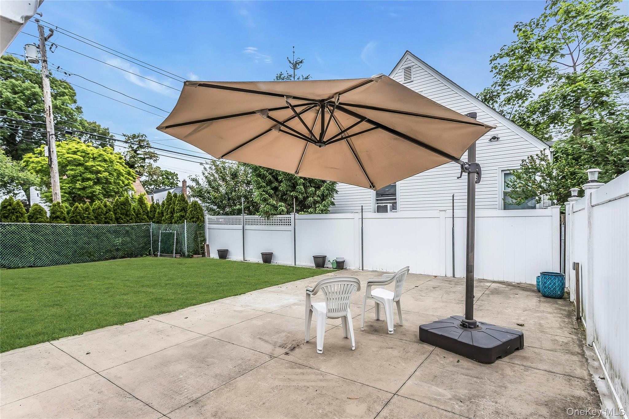 103 Union Street Valley Stream, NY 11580 - Photo 18 of 19 a view of a patio with a table and chairs under an umbrella