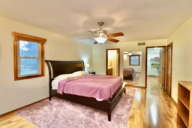a bedroom with bed and wooden floor