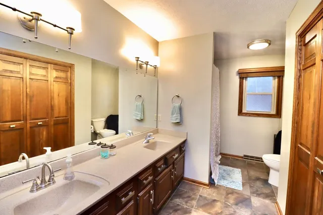 a bathroom with a double vanity sink a mirror and a bathtub