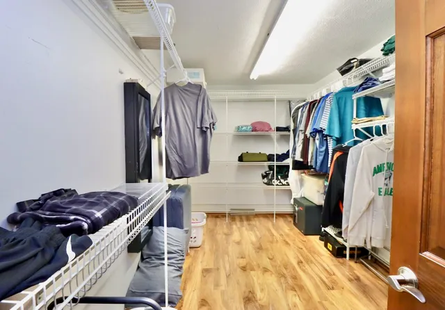 a view of walk in closet with clothes and shoes