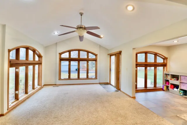 a view of an empty room with a window and a kitchen