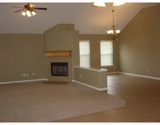 a view of an empty room with a fireplace and a window