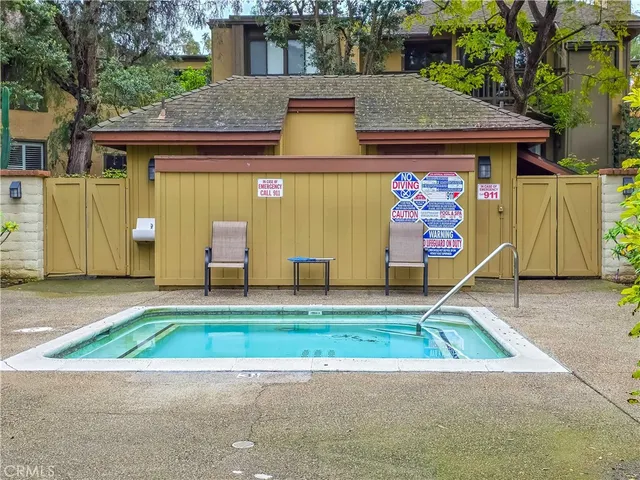 a view of a swimming pool with a patio and fire pit
