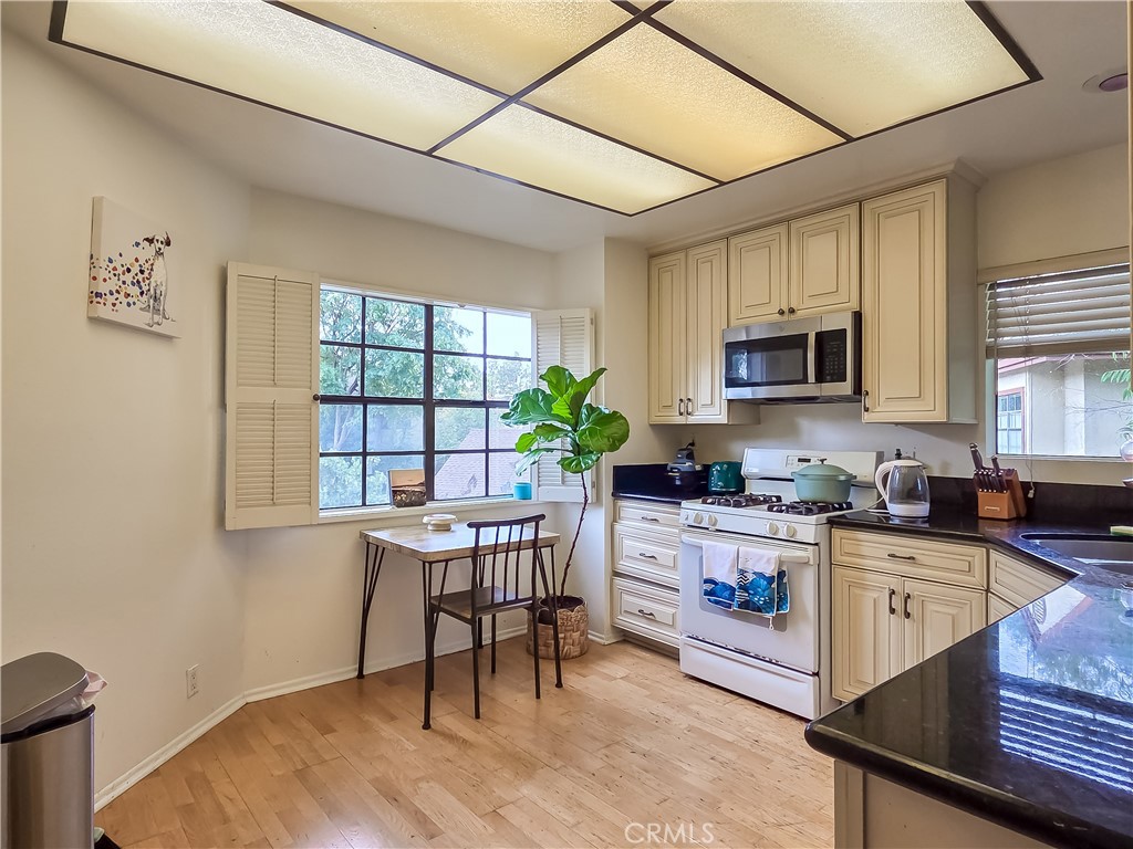 59 Rainbow Ridge Irvine, CA 92603 - Photo 4 of 35 a kitchen with a table chairs microwave and cabinets