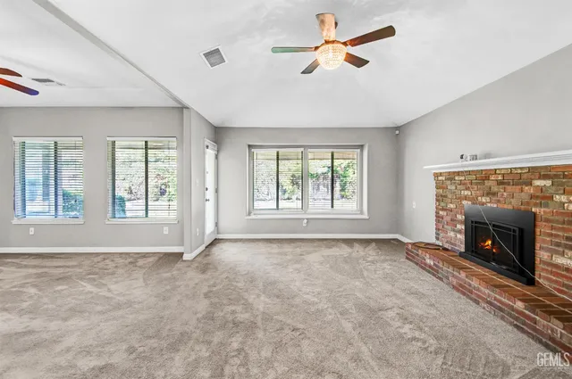 a view of an empty room with a fireplace and a window