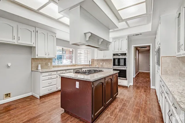 a kitchen with stainless steel appliances granite countertop a stove and a refrigerator