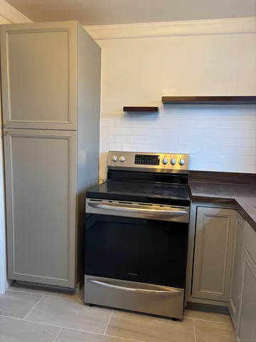 a stove top oven sitting inside of a kitchen