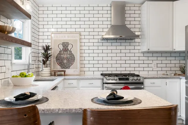 a kitchen with a sink and a stove next to a window
