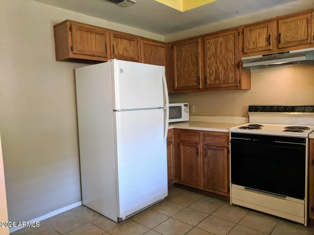 a kitchen with a refrigerator sink and cabinets
