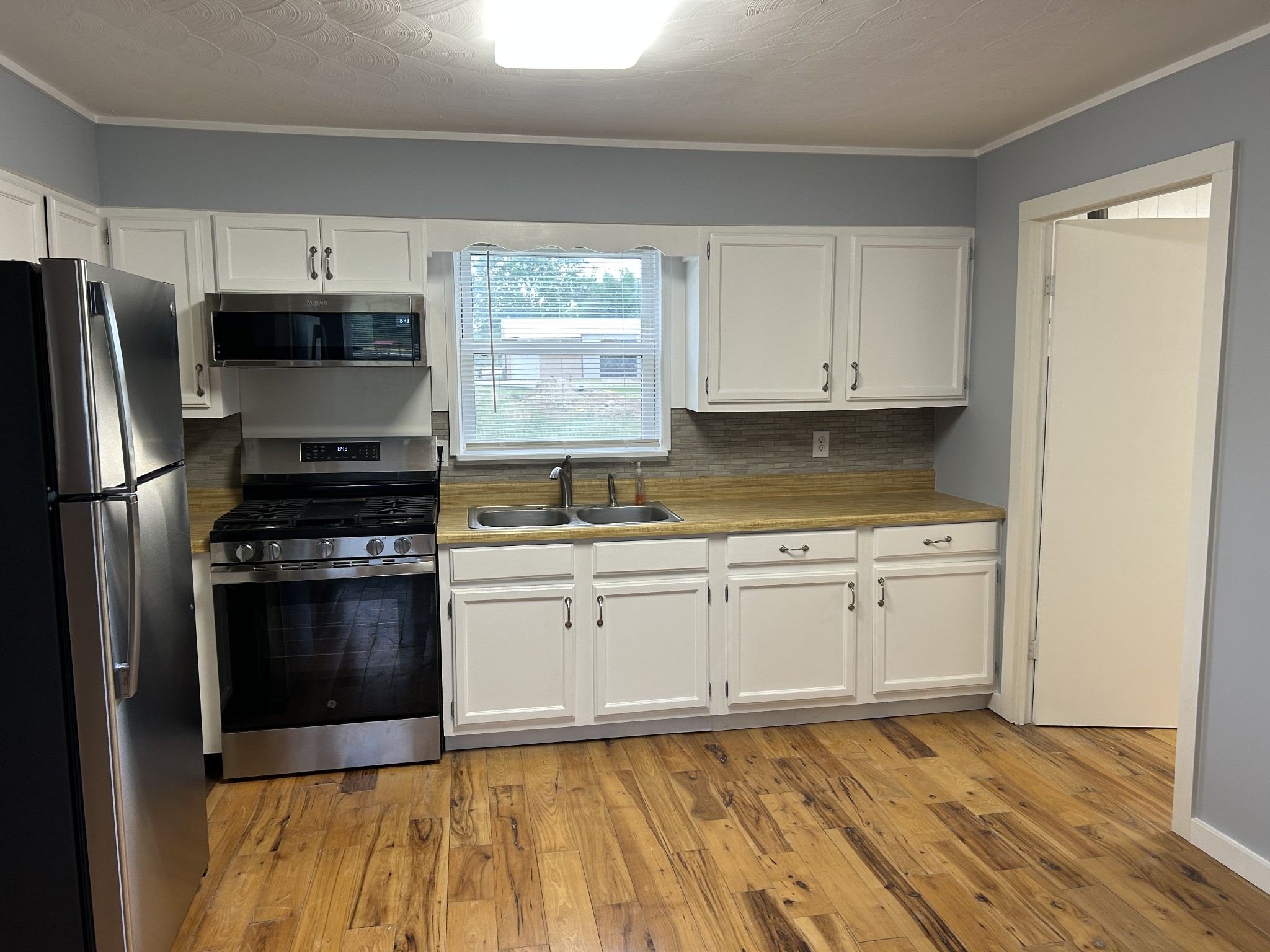 20 Ball Park Road Big Sandy, TN 38221 - Photo 18 of 33 a kitchen with granite countertop a sink stainless steel appliances and white cabinets