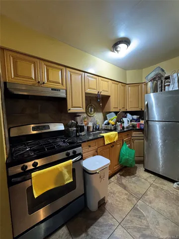 a kitchen with a stove a refrigerator and storage
