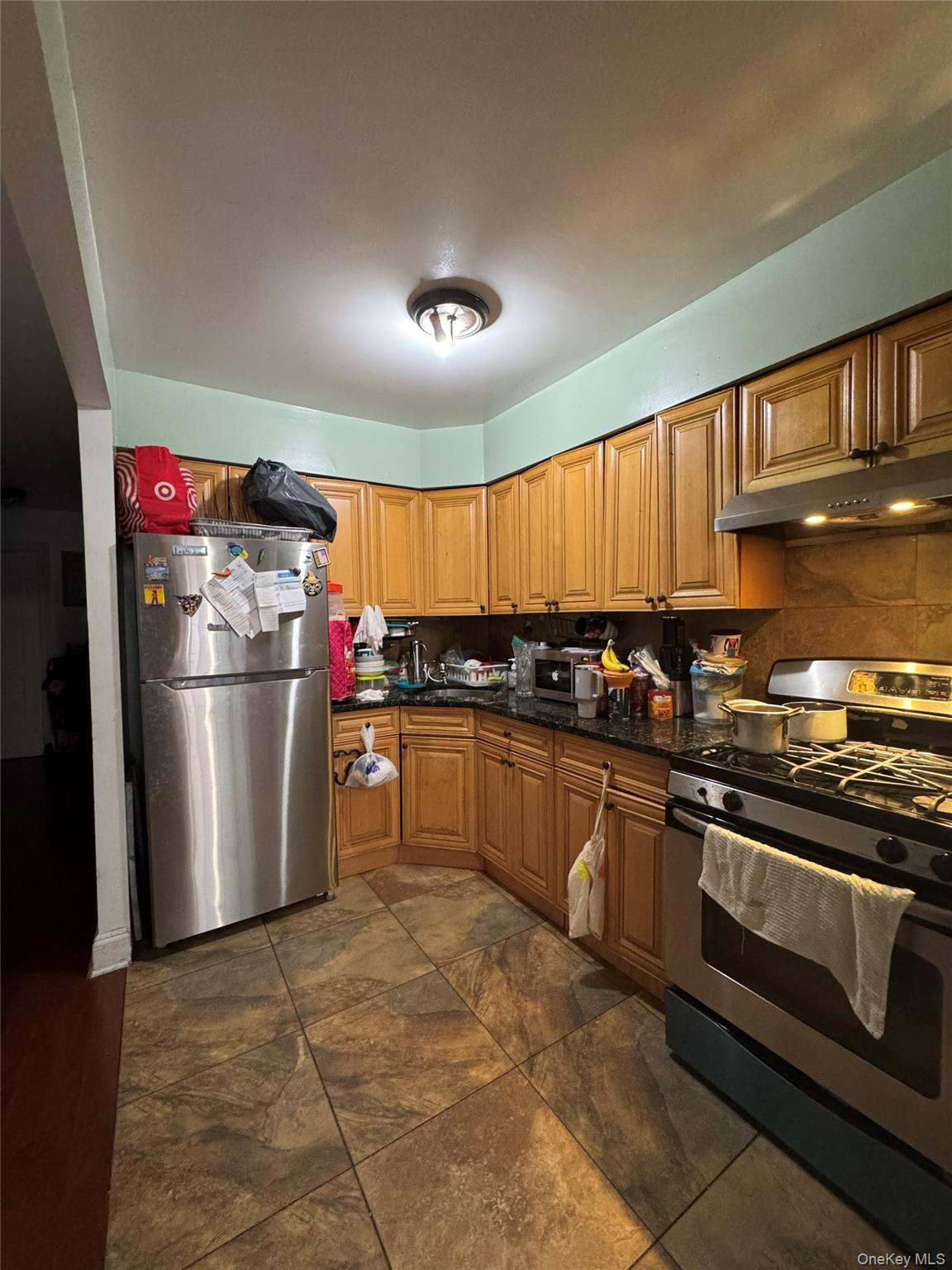 101-20 39th Avenue Queens, NY 11368 - Photo 8 of 17 a kitchen with stainless steel appliances granite countertop a refrigerator a sink dishwasher a stove and white countertops with cabinets