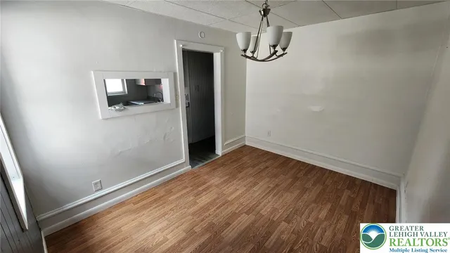 a view of empty room with wooden floor and windows