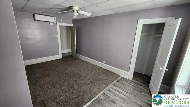 an empty room with wooden floor and staircase