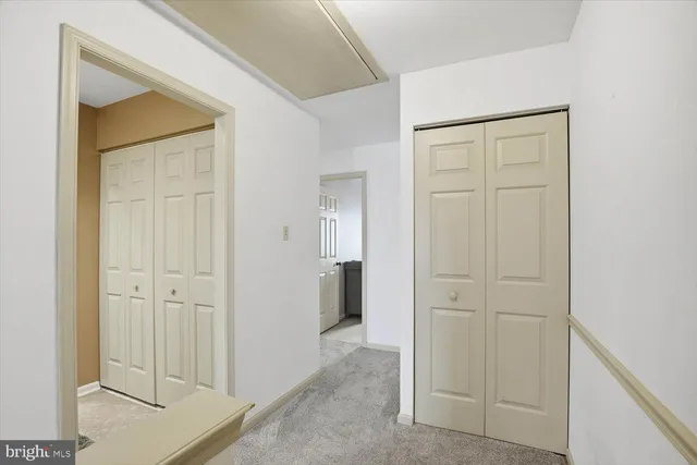 a view of a hallway with a livingroom and a bathroom