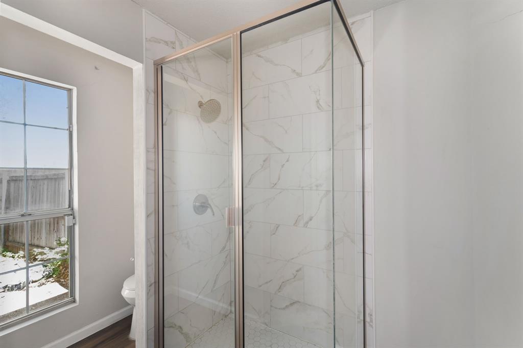 1019 Danforth Court Arlington, TX 76017 - Photo 23 of 37 a bathroom with a glass shower door