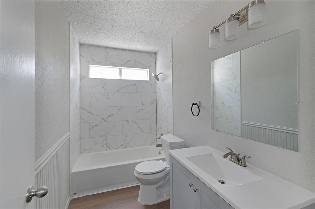 1019 Danforth Court Arlington, TX 76017 - Photo 32 of 37 a bathroom with a bathtub shower sink mirror vanity and toilet