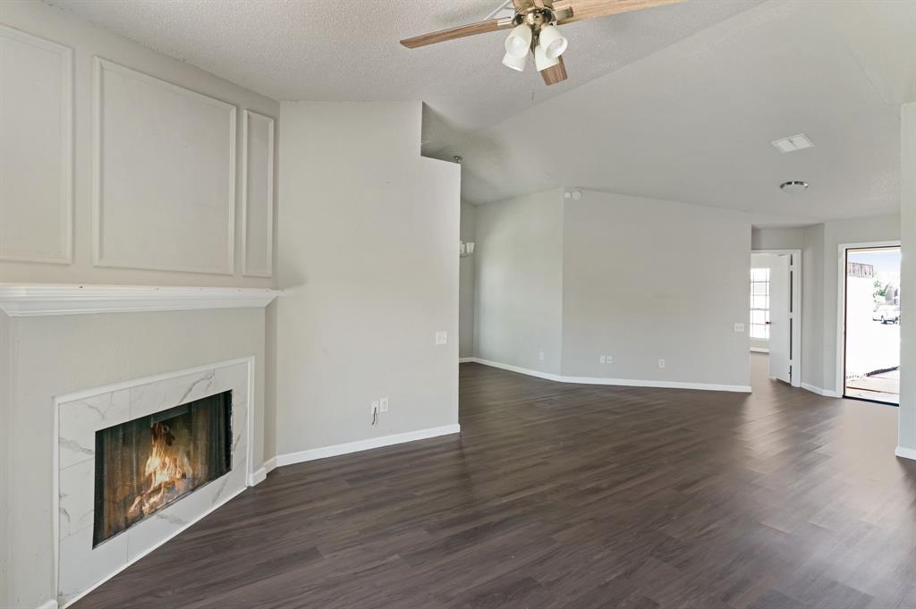 1019 Danforth Court Arlington, TX 76017 - Photo 9 of 37 a view of an empty room with wooden floor fireplace and a window