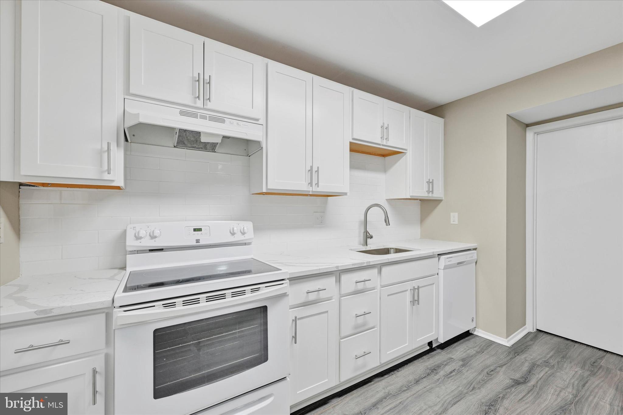 3447 Santee Road Baltimore, MD 21236 - Photo 12 of 32 a kitchen with white cabinets and white appliances
