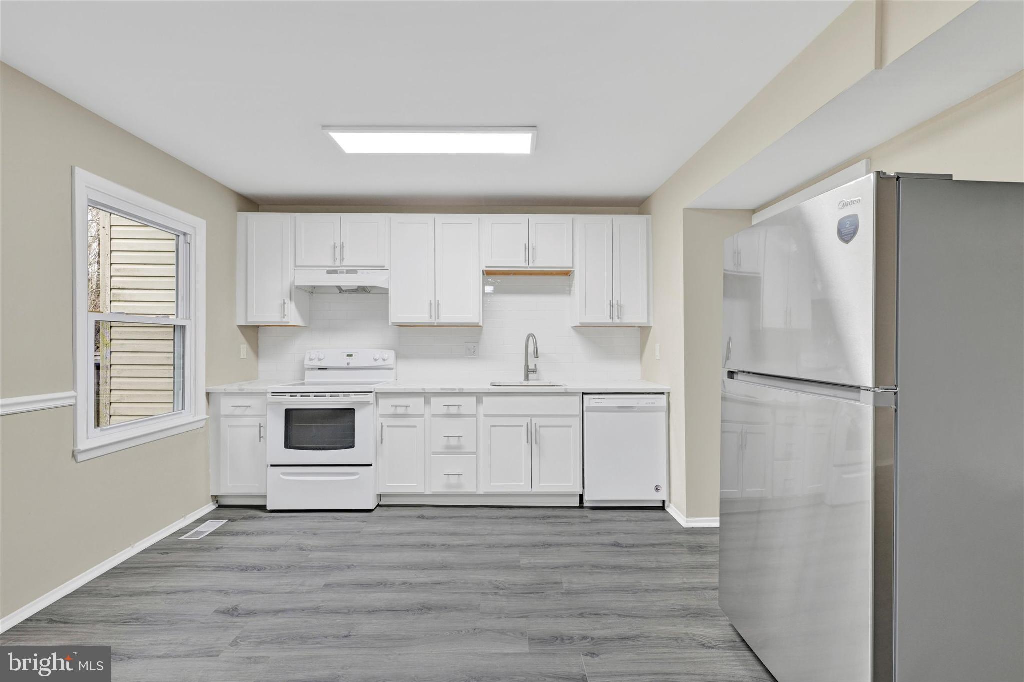 3447 Santee Road Baltimore, MD 21236 - Photo 10 of 32 a kitchen with white cabinets and white appliances