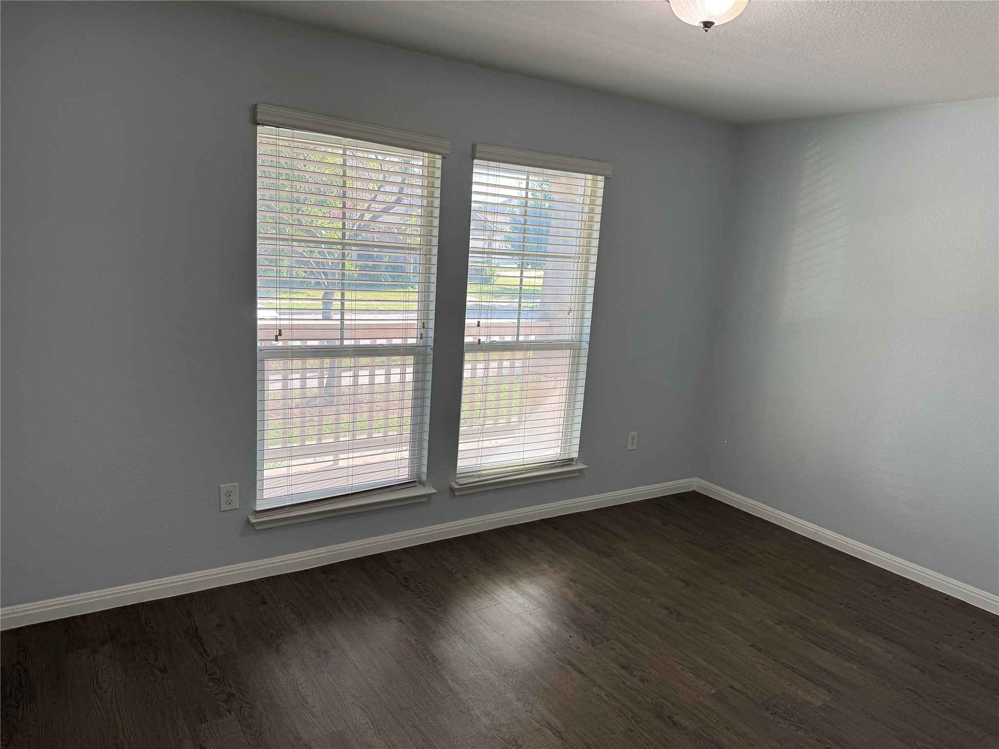 1520 Portchester Castle Path Pflugerville, TX 78660 - Photo 9 of 26 Hardwood floors and natural light from two windows enhance this airy bedroom.