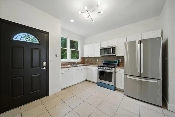 a kitchen with granite countertop stainless steel appliances a stove sink and refrigerator